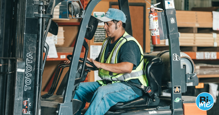 A man working on a forklift in a factory