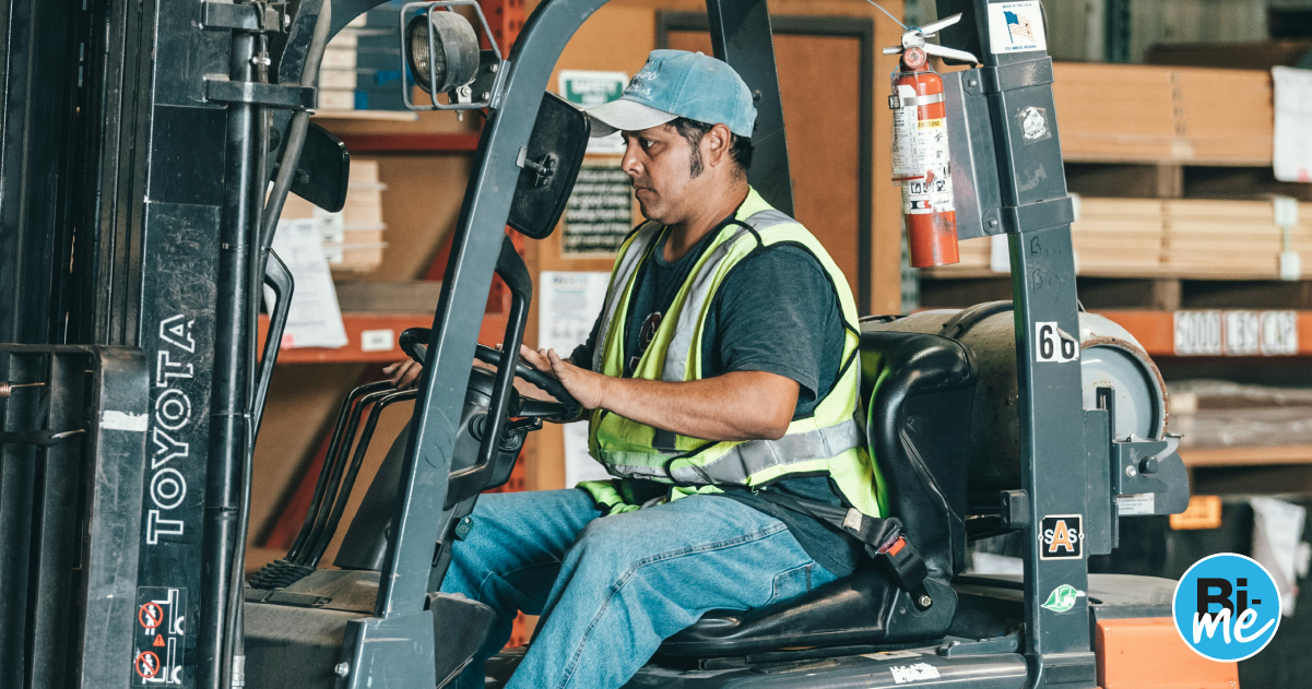 A man working on a forklift in a factory
